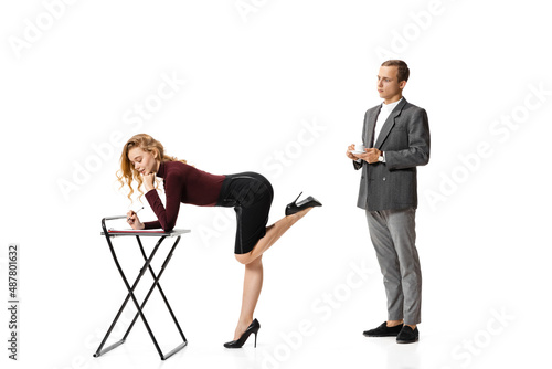 Flirt at work space. Two stylish office workers in business suits isolated on white background. Human rights, diversity, relation, fashion and business concept © master1305