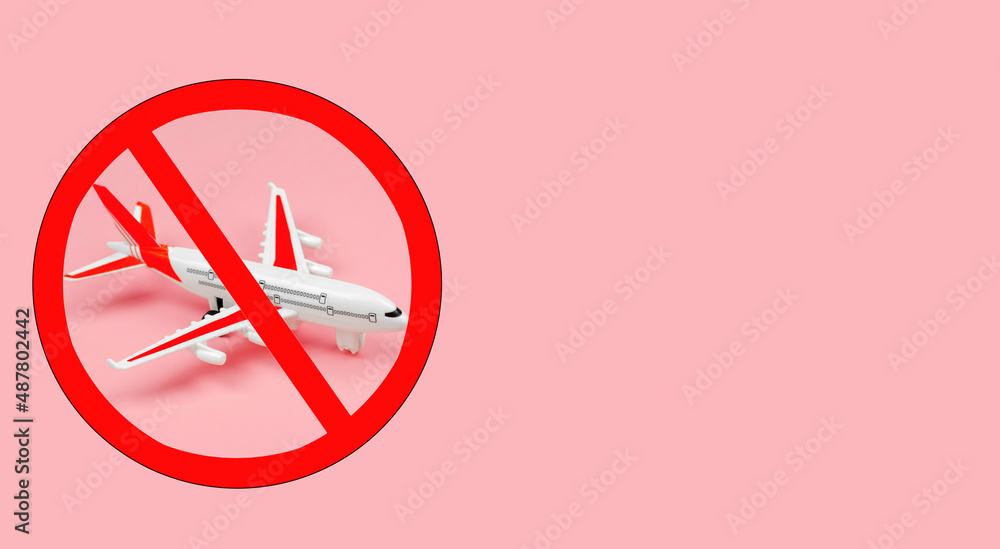 Top view of a toy plane with a prohibition sign on a pink background. Overflight ban Top view of a toy plane with a prohibition sign on a pink background. Overflight ban
