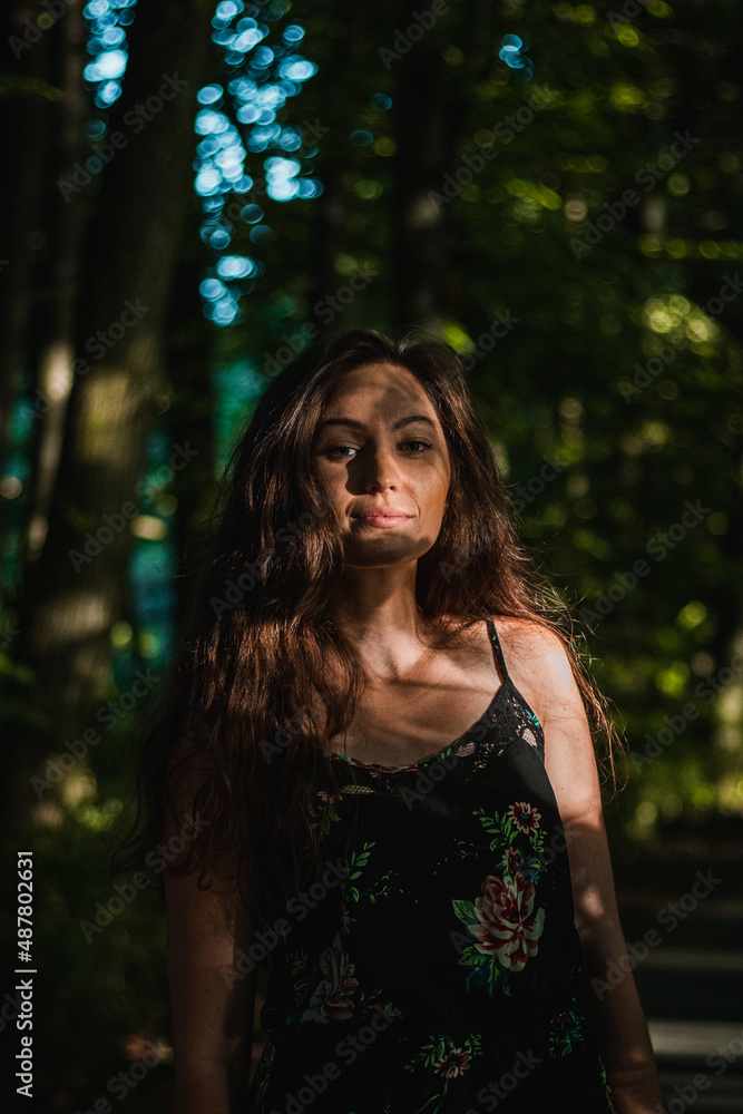 A 35 year old brunette woman in a forest wearing a small top