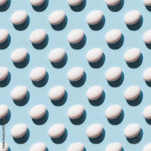 Fototapeta Naklejka Na Ścianę i Meble -  Organic white eggs on blue background. Abstract pattern. Eggs in isometric.