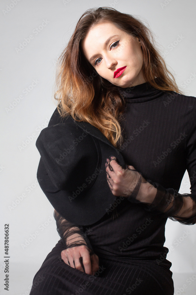 White young european woman in total black isolated on grey with red lips White young european woman in total black isolated on grey with red lips