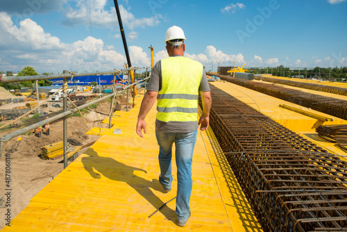 Φωτογραφία foreman in a protective helmet walks around the construction site during the con