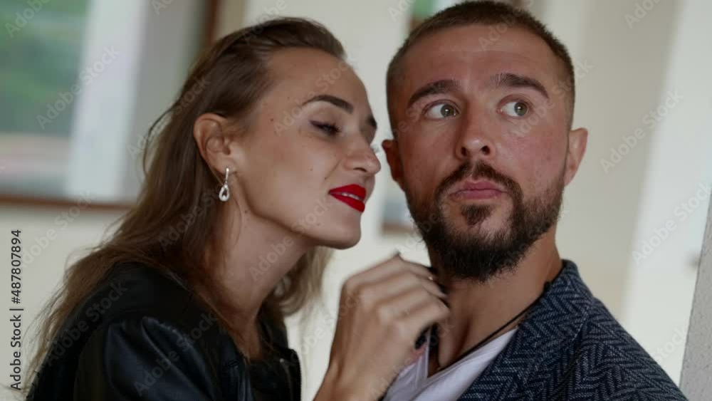 portrait of a young couple. a blonde with bright lipstick touches a man with a beard, laughs and looks at him. the camera is moving portrait of a young couple. a blonde with bright lipstick touches a man with a beard, laughs and looks at him. the camera is moving
