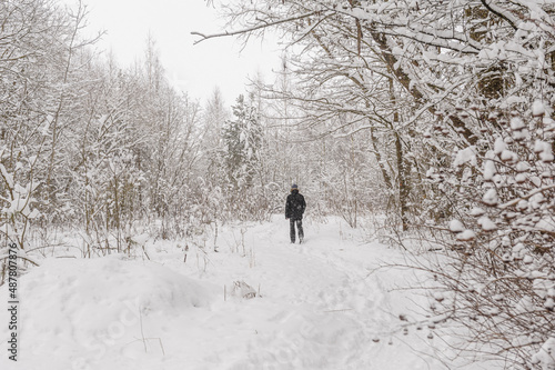 Man walking on forest path covered with snow. Snowy path through forest. Cold winter panorama. Weather forecast scene. Travel freedom background copy space. Person outdoors