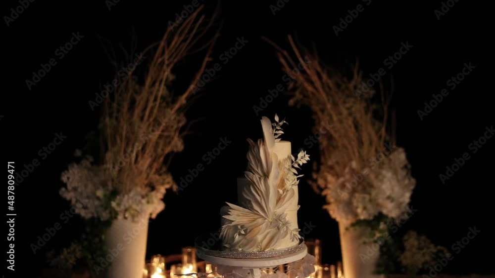 beautiful wedding cake near the wedding arch in the evening beautiful wedding cake near the wedding arch in the evening