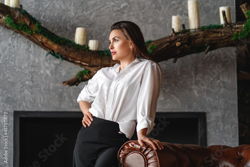 Wallpaper Mural a young woman is standing with her hand resting on the sofa. In the background is a fireplace decorated with a decorative log and candles. Torontodigital.ca