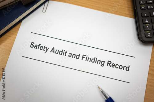 Safety audit and finding record document folder which is placed on wooden desk surface. Industrial and business document object photo. photo