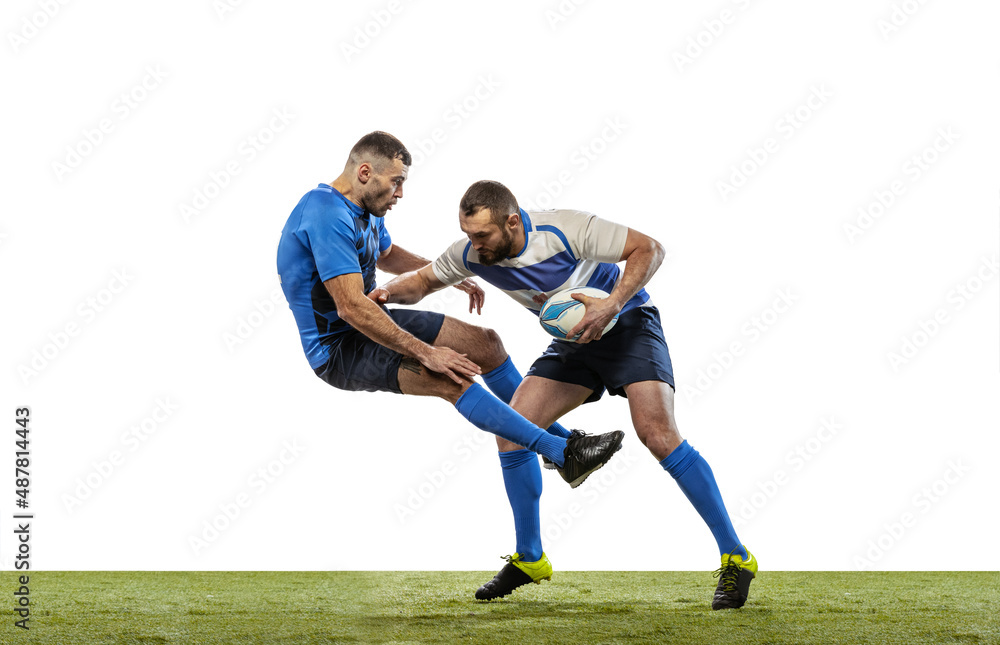 Dynamic portrait of male rugby players playing rugby football on grass field isolated on white background. Sport, activity, health, hobby, occupations concept