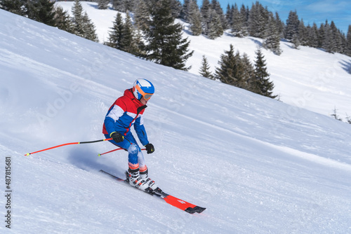 A teenage skier skiies down the montain.With copy space