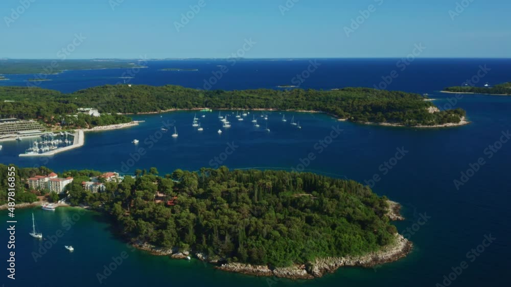 Big forestry islands and peninsulas surrounded by dark blue water. Small yachts drifting in marina port in Adriatic sea on sunny day. Panorama view Big forestry islands and peninsulas surrounded by dark blue water. Small yachts drifting in marina port in Adriatic sea on sunny day. Panorama view