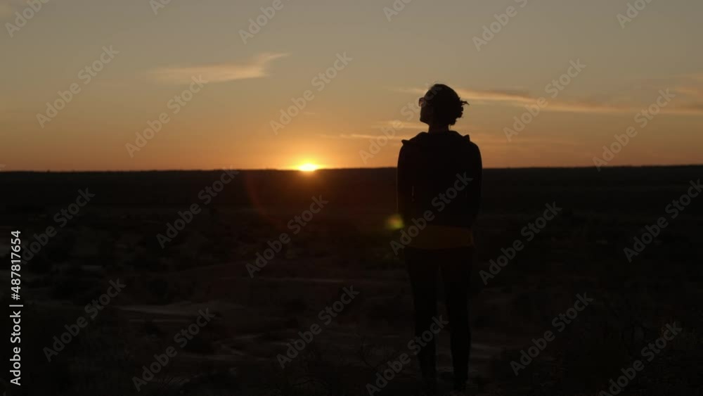 Girl looking out over a beautiful Australian sunset in a dry desert. Girl looking out over a beautiful Australian sunset in a dry desert.