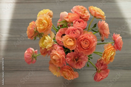 Close up shot of beautiful orange and red ranunculus bouquet. Visible petal structure. Detailed bright patterns of flower buds. Top view, background, copy space for text.