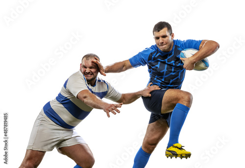 Two athletes, rugby players playing rugby football on grass flooring isolated on white background. Sport, activity, health, hobby, occupations concept