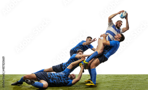 Foto Muscled men, professional rugby players playing rugby football on grass field isolated on white background