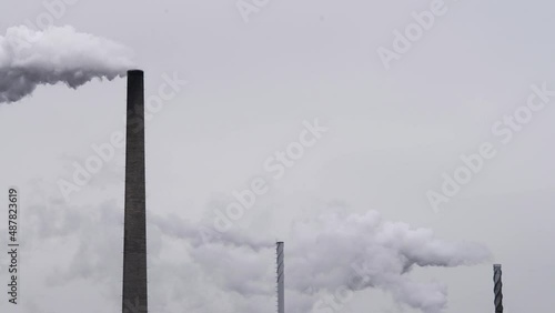 Multiple Factory chimney smoke on a gray day. Monochromatic.