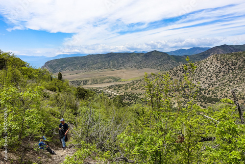 A man with a child on the background of landscapes of the Black Sea and the Crimean mountains on the Golitsyn trail. Crimea.