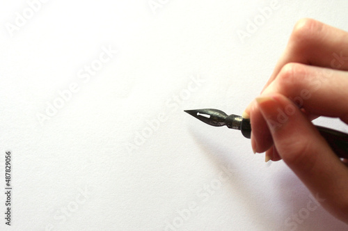 Wallpaper Mural female hand holding a black fountain pen on white paper with copy space  Torontodigital.ca