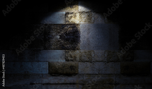 Fondo de pared de roca. Ambiente de piedra oscura con iluminación puntual de foco superior.