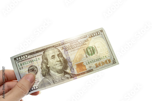 New sample money. Close up perspective view of hundred-dollar bill in human hand with sunlight.