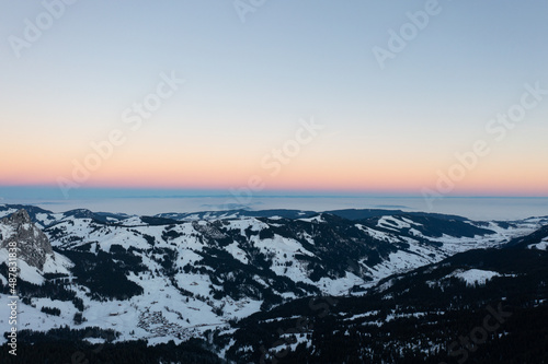 Amazing sunrise with red sky and a beautiful landscape in the wonderful region in Switzerland called Mythenregion. Beautiful mountain called Mythen and an epic sea of fog in the background.