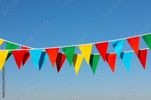 Buntings with colorful triangular flags against blue sky