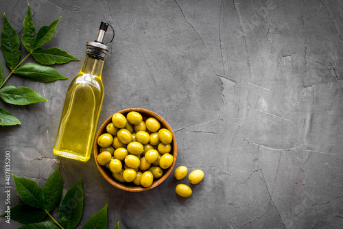 Fotografie, Obraz Bottle of olive cooking oil with green olives in bowl