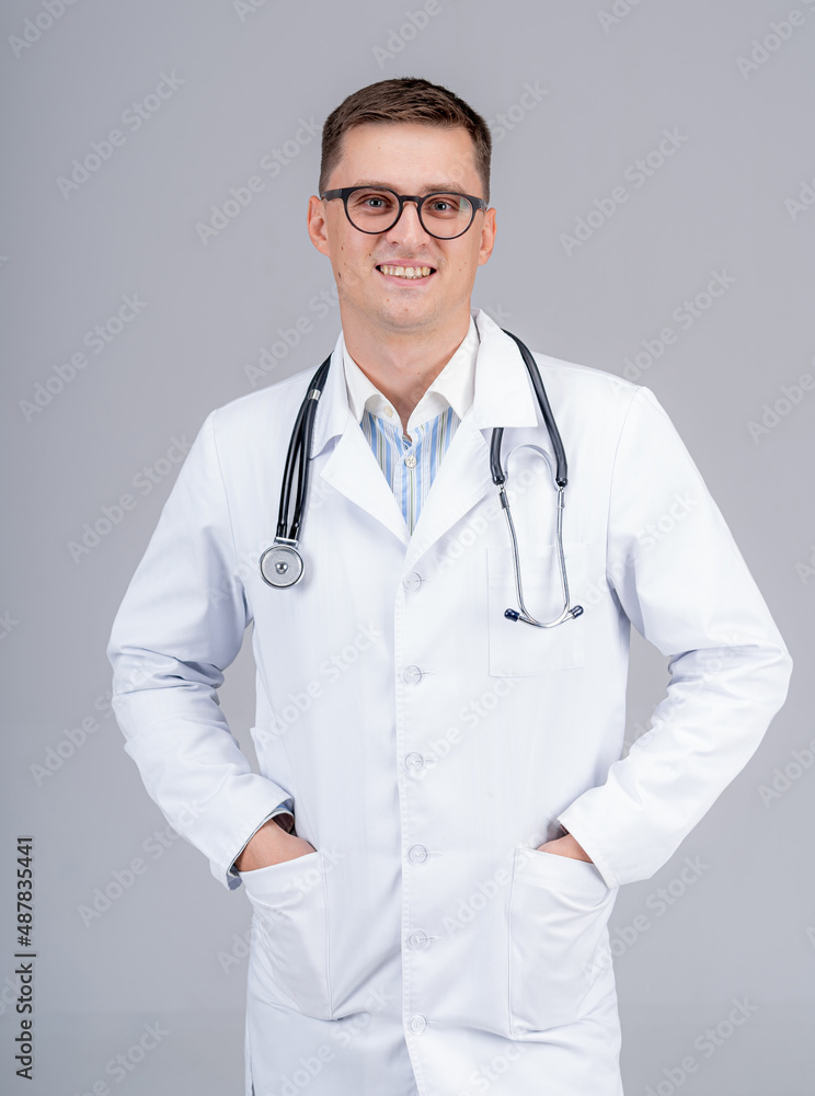 Practitioner put hands in pockets. Medic in glasses with phonendoscope on light background. Closeup. Practitioner put hands in pockets. Medic in glasses with phonendoscope on light background. Closeup.