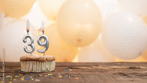 Happy birthday card with candle number 39 in a cupcake against the background of balloons. Copy space happy birthday for thirty nine years old photo