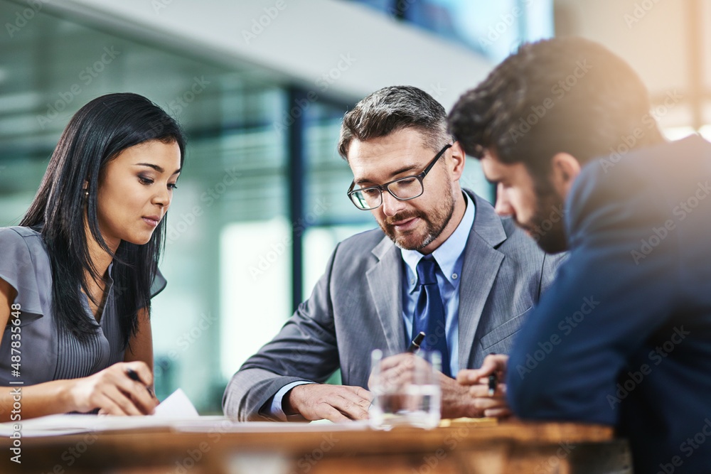 Deciding on their most feasible options to move forward with. Shot of a group of colleagues working together in an office. Deciding on their most feasible options to move forward with. Shot of a group of colleagues working together in an office.