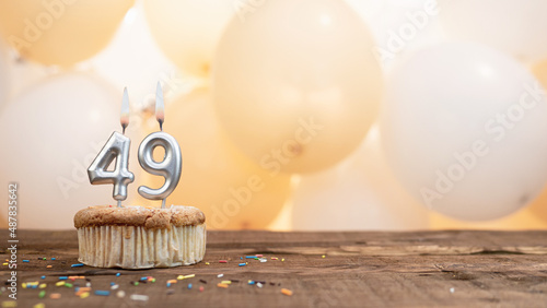 Happy birthday card with candle number 49 in a cupcake against the background of balloons. Copy space happy birthday for forty nine years old photo