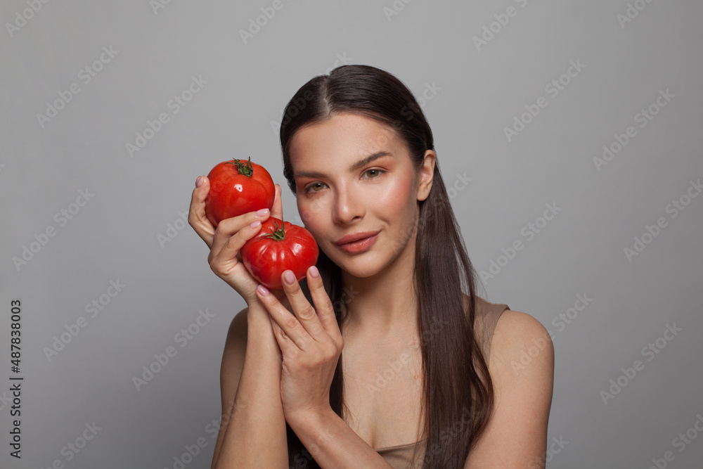 Beautiful woman holding two ripe tomatoes. Healthy eating and diet concept Beautiful woman holding two ripe tomatoes. Healthy eating and diet concept