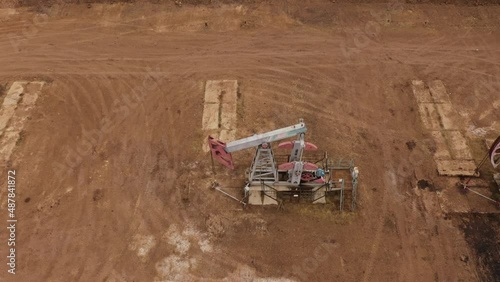 Pump jack in vast oil fields in Russia. Pipelines transporting oil from oil pumps, aerial drone shot