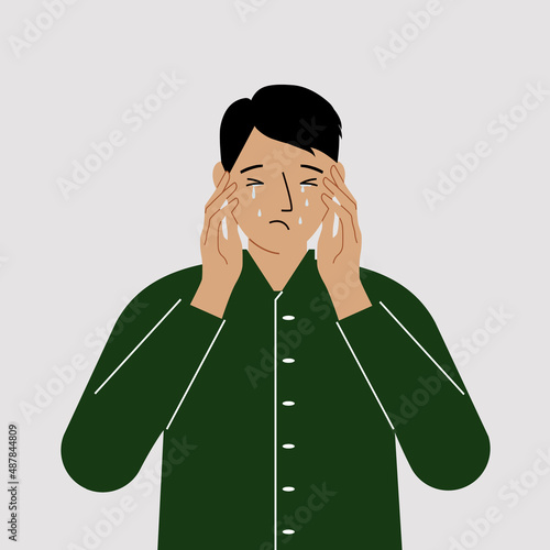 Upset man cries and holds his head with his hands. The concept of resentment, pain and depression.
