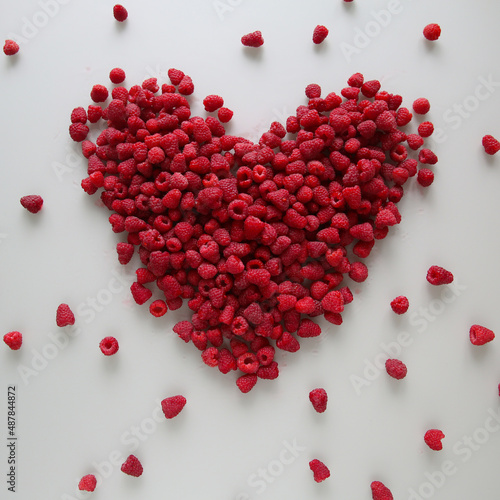 Fresh raspberries in the shape of a heart on a white background