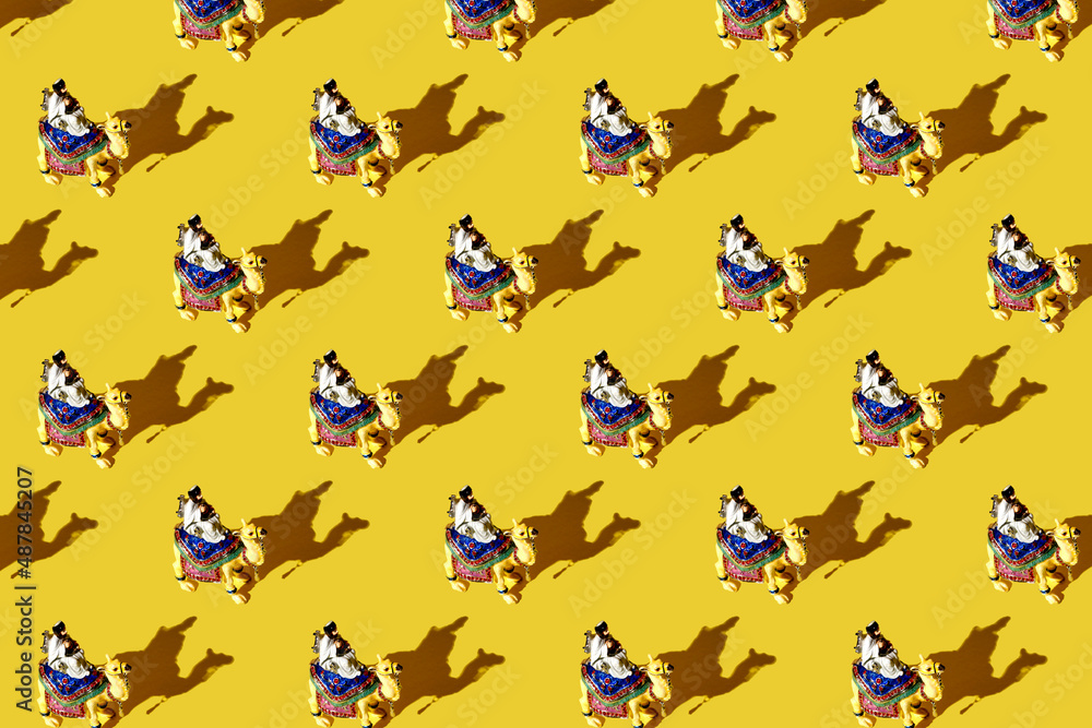 Trendy pattern made with figure of a camel with a driver, a Bedouin. Silhouette of camel caravan in the desert sand during sunrise. Cameleer with camels caravan, silhouettes and shadows.