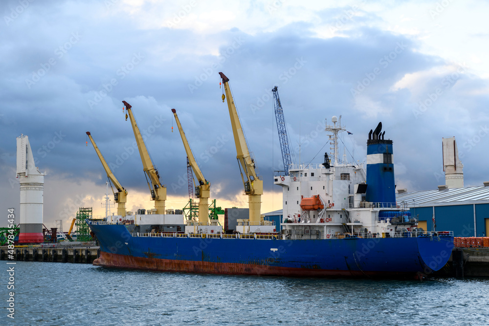 Blue refrigerated cargo vessel moored in port. Loading of cargo.