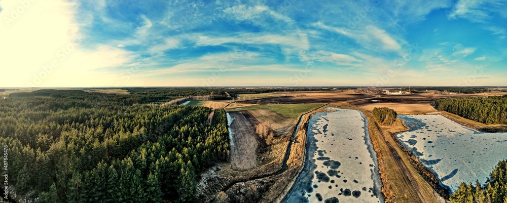 Panorama.Aerial view of fish ponds on a sunny day among the fields and forest of the Polish countryside.
