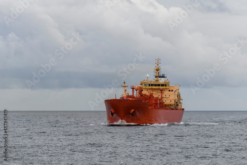 Tanker at sea. Cargo vessel with red hull sailing.