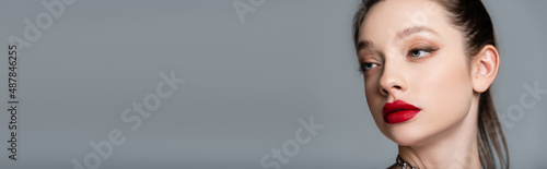 young stylish woman with red lips looking away isolated on grey, banner.