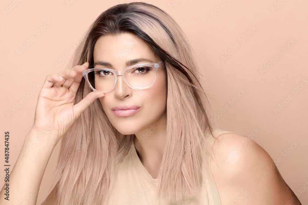Gorgeous model girl with trendy clear glasses looking at camera posing in studio. Fashion eyewear and clear vision concept Gorgeous model girl with trendy clear glasses looking at camera posing in studio. Fashion eyewear and clear vision concept