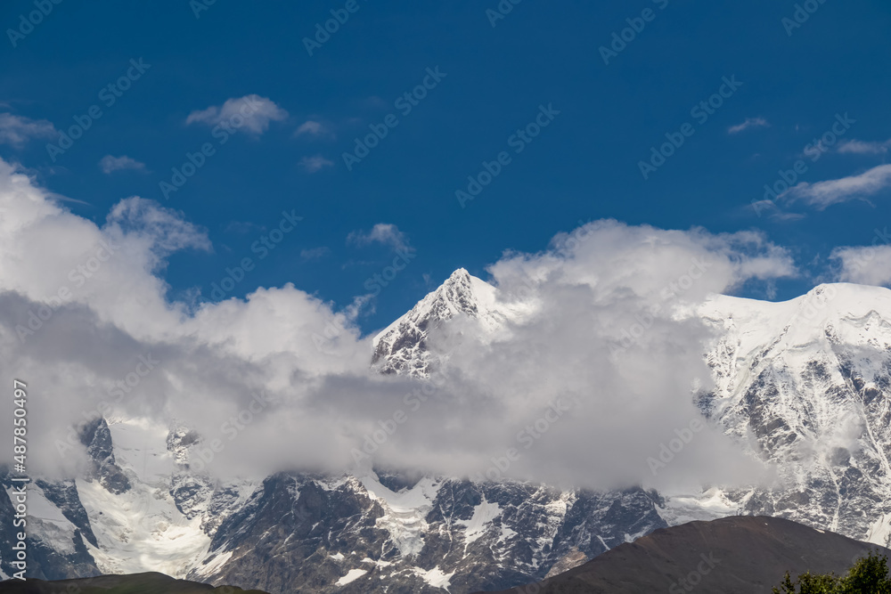 Amazing view from Chubedishi viewpoint on the Shkhara Glacier, near the village Ushguli the Greater Caucasus Mountain Range in Georgia, Svaneti Region. Snow capped mountains covered by clouds.