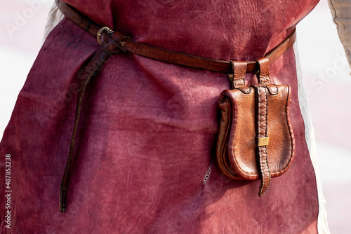 a red leather worker's apron and a leather purse on a belt