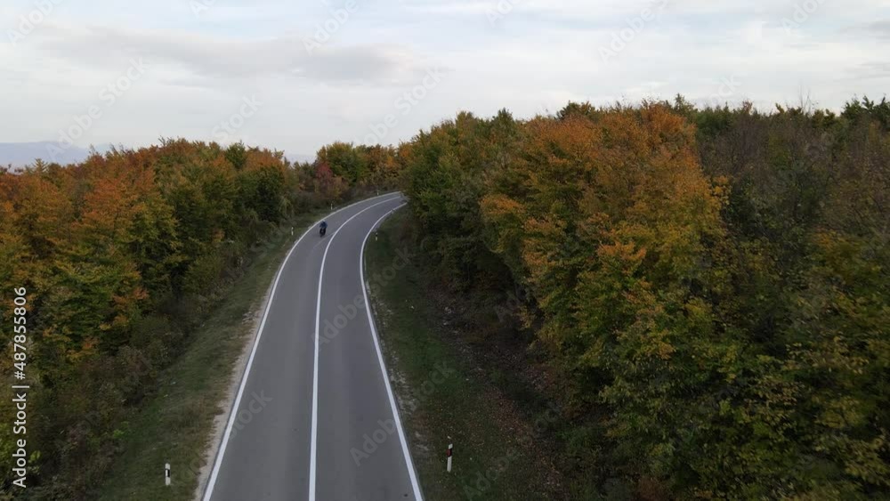 Top view on the road drone follow motorcycle bike while drive travel and tourism transportation concept in spring or summer day trough the fields and trees in sunny sunset near Knjazevac Serbia Top view on the road drone follow motorcycle bike while drive travel and tourism transportation concept in spring or summer day trough the fields and trees in sunny sunset near Knjazevac Serbia