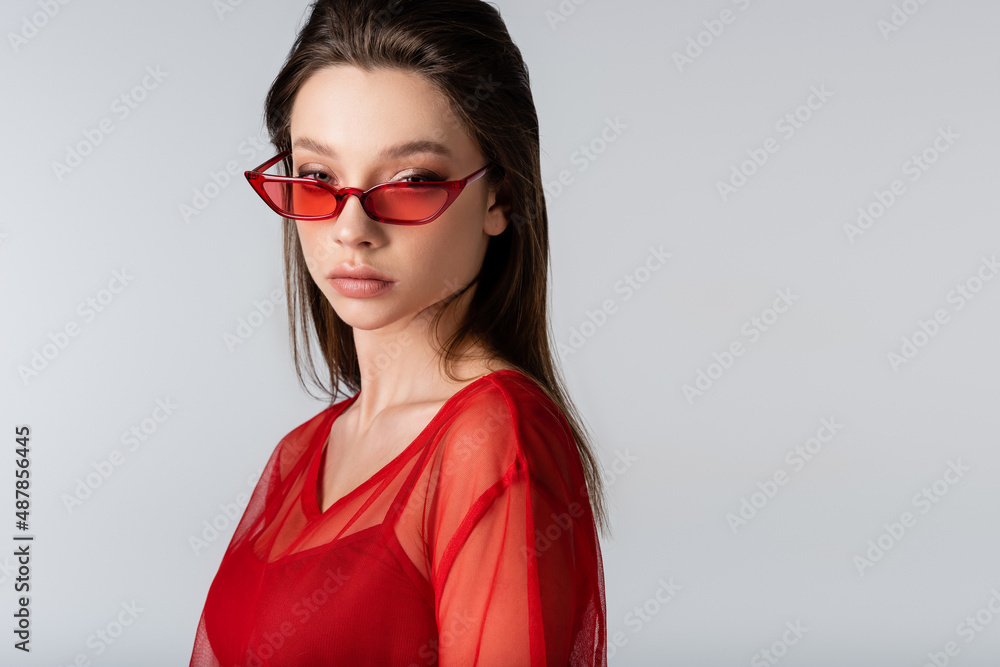 young model in red trendy sunglasses isolated on grey. young model in red trendy sunglasses isolated on grey.