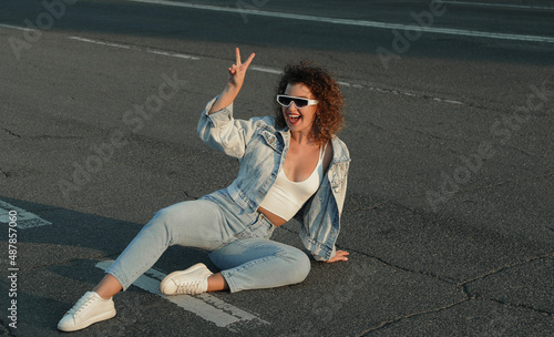 smiling woman is sitting on the road, freedom concept