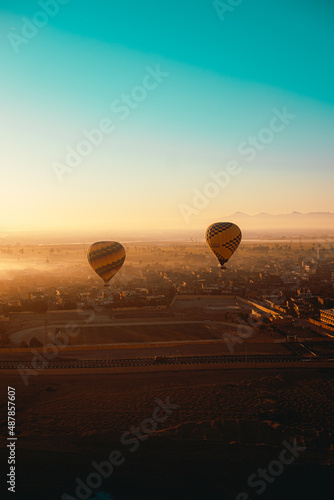 Luxor Egypt January 2021 Vertical shot of two hot air balloons in luxor, egypt. Amazing early morning sunrise illuminated over the amazing foggy landscape