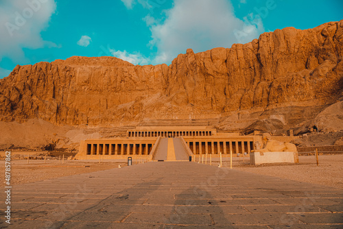 Closer view of the amazing hatshepsut temple near luxor egypt. Single road leading to the huge temple in the mountain. Empty during early morning hours