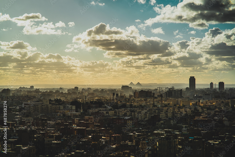 Amazing panorama of the huge Cairo city, great pyramids of Giza visible in the distance. Cloudy warm winter day, as seen from the Salah Al Din castle observatory area
