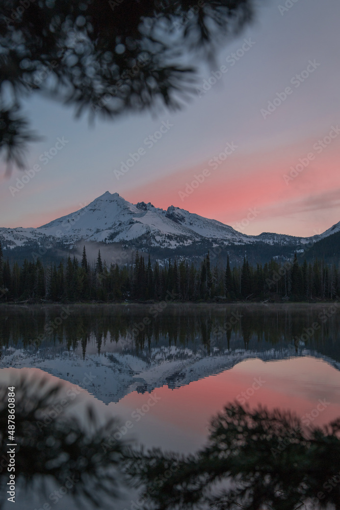 Sunrise at a high elevation lake with dreamy mountain scenery and reflections