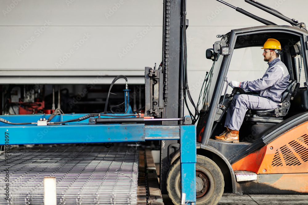 A forklift driver at steel factory transporting iron construction and armature. A forklift driver at steel factory transporting iron construction and armature.